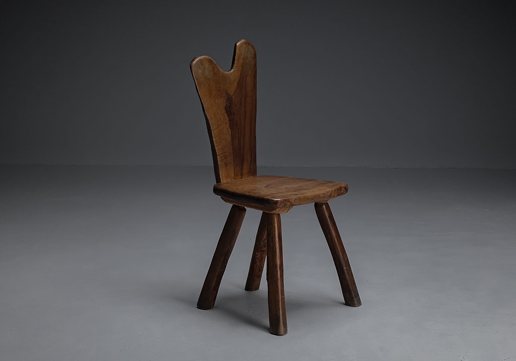Tony Bain chair in olive wood and cast iron. Front view, detail of the wood grain visible on the backrest