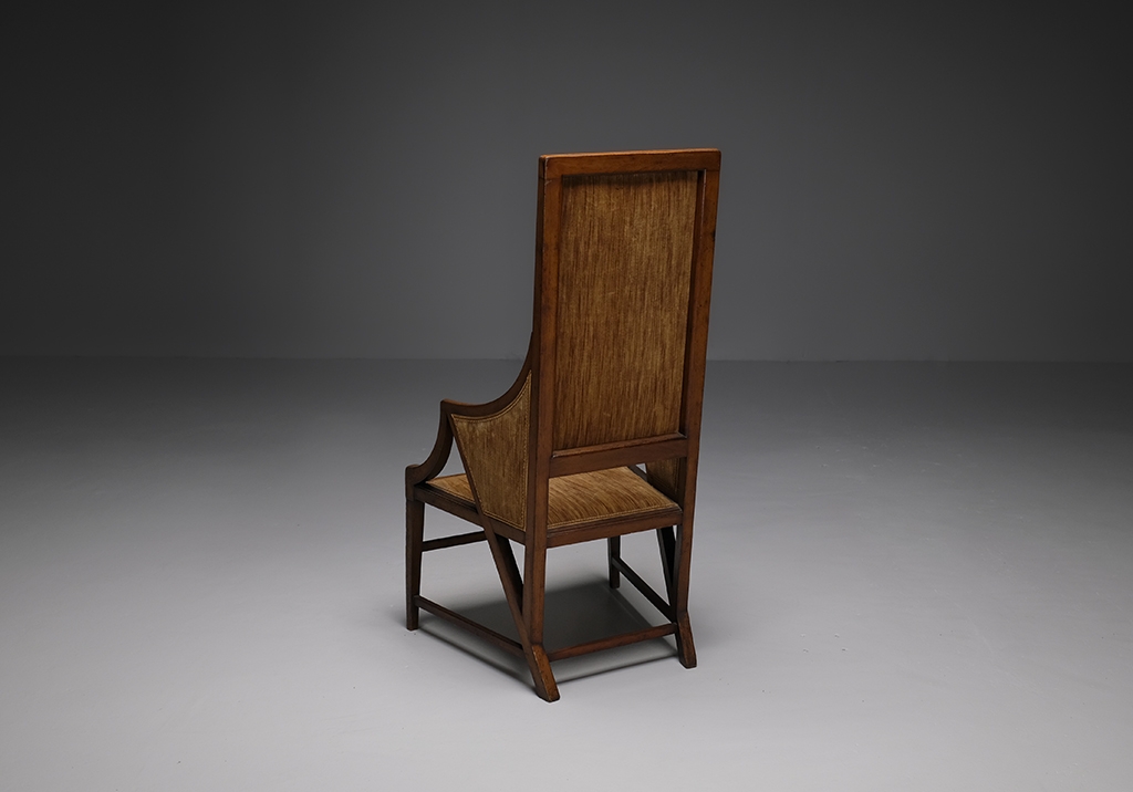 Walnut armchair by Giacomo Cometti: Overall view of the armchair placed with the back obliquely