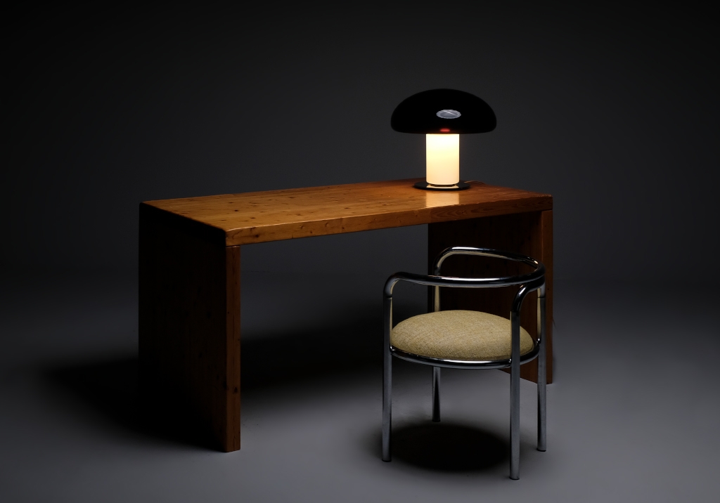 Pine Wood Desk from the 60s: overview with a lamp on. A chair is arranged in front of the desk