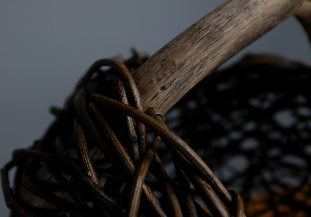 Wicker and Sauvage Oak Basket: detail of raw woven wicker close to the handle