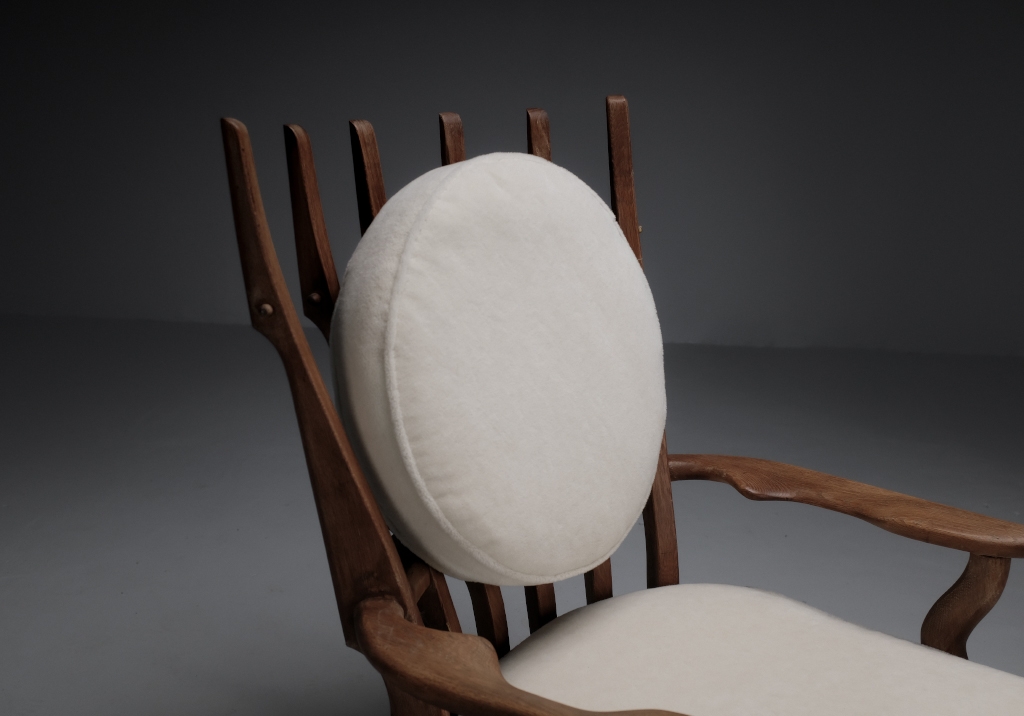 Oak armchair by Guillerme et Chambron: details on the round backrest cushion seen from the left