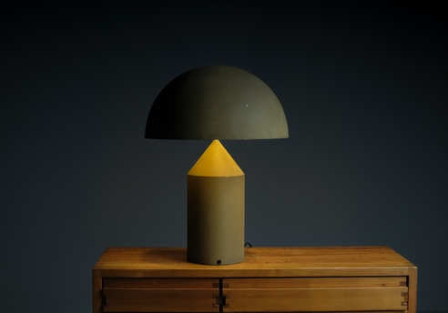 Atollo table lamp: view of the lit lamp in a dimly lit environment
