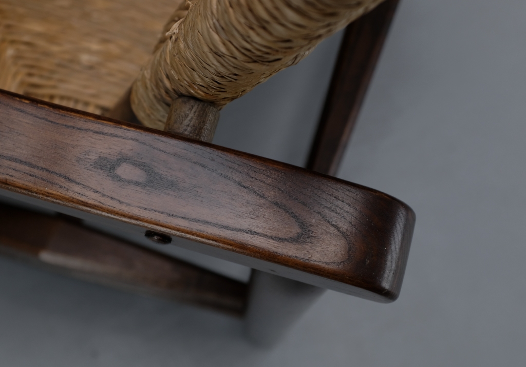 Charlotte Perriand armchair: detail on the patina and veining of the wood of the armrest